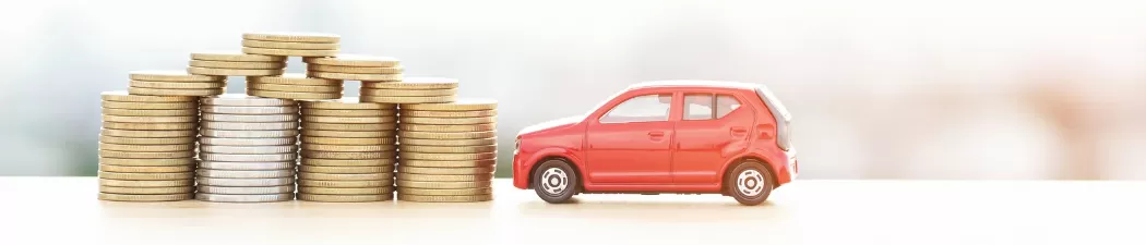 small car next to stack of coins